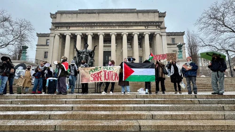 Pro-Palestinian students holding "Money Talks Strike Tuition" banner and Palestinian flag at a protest in front of Low Library on the Columbia University campus New York, NY USA - January 19, 2024