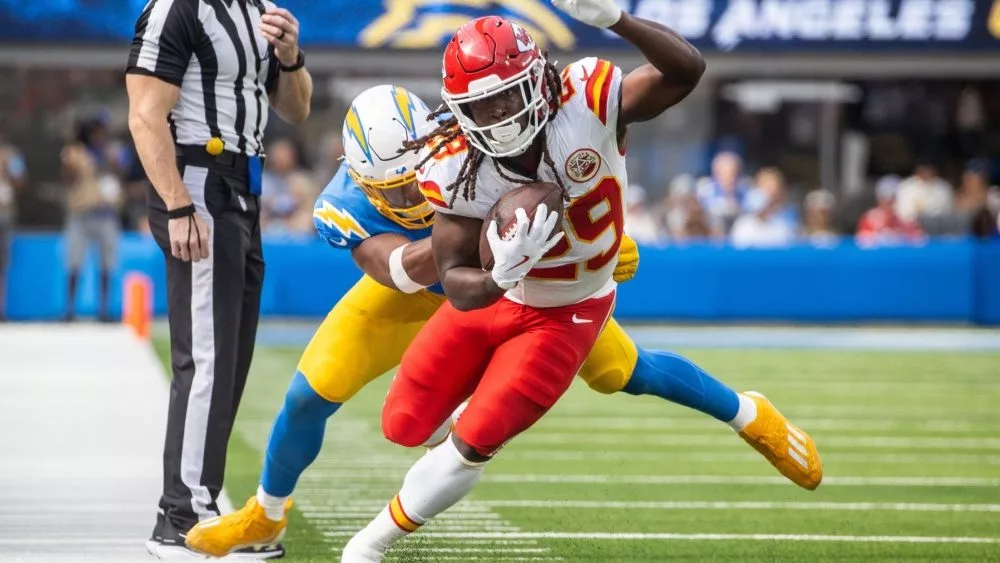 KC Chiefs running back Kareem Hunt #29 runs past LA Chargers linebacker Daiyan Henley #0 during an NFL football game at SoFi Stadium, Aug. 17, 2024, in Inglewood, Calif.