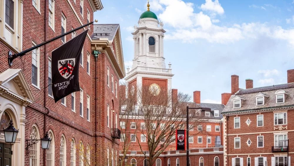 View of the architecture of the famous Harvard University in Cambridge, Massachusetts, USA showcasing it brick buildings with some students and locals passing by . Cambridge, MA, USA - March 15, 2024