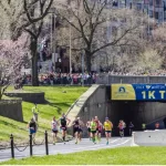 Runners in the Boston Marathon pass the 1 kilometer to go line on their way to the finish line