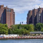 Towers of the East River Co-ops (1956) in the Lower East Side^ NYC. In the foreground is the East River and East River Park under renovation.New York^ NY - August 13^ 2022