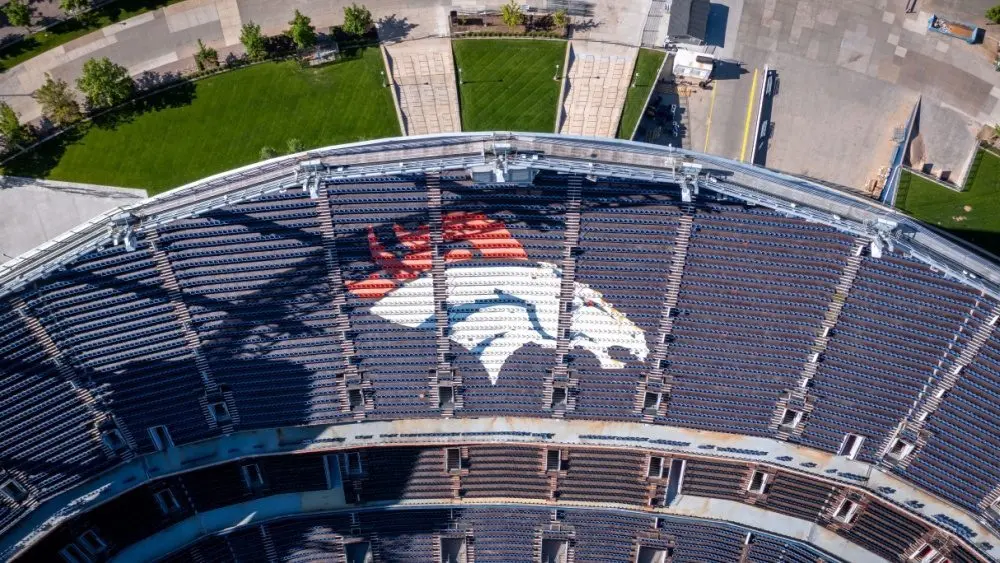 Aerial Top-Down View of Denver Broncos Logo in Empty Stadium Seats at Empower Field May 26^ 2022 Denver^ Colorado