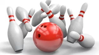 red-bowling-ball-knocking-over-pins-in-a-perfect-strike