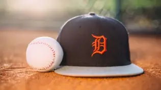 MLB Baseball ball with Detroit Tigers cap on pitchers mound.