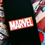 Marvel comics logo on the background of comic pages