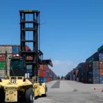 Port of Los Angeles - Port of Long Beach^ CA. Stacked shipping containers and forklift. 2024 May 3