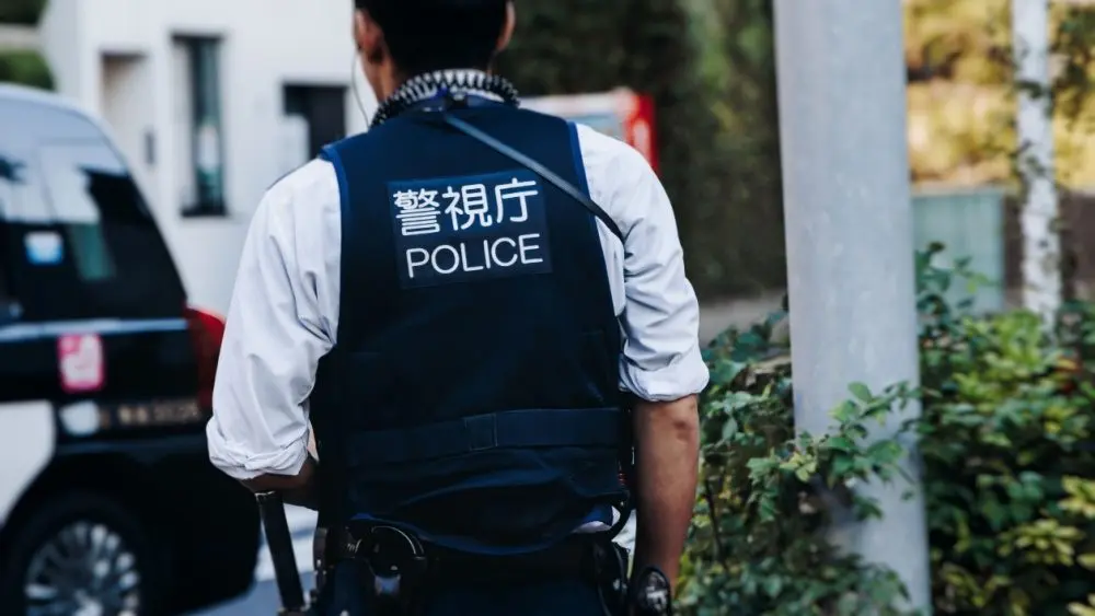 Japanese police squad formation in protective uniform with "Police" logo^ policemen patrol maintain public during political demonstration protest rally in the streets of Tokyo city center^ Japan