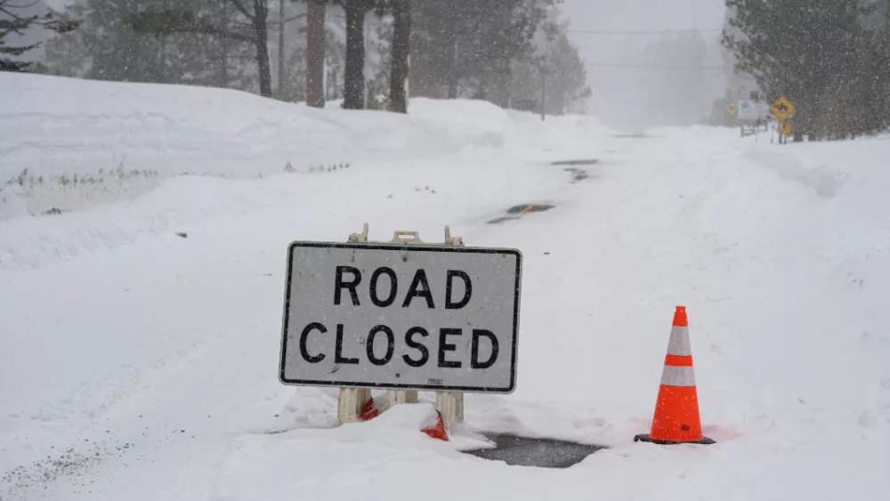 "Road Closed" sign during atmospheric river winter storm event in the Sierra Nevada mountains.