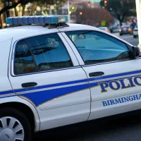 Birmingham^ Alabama / USA - April 6^ 2020: A police car turning a corner in the downtown financial district of the city.