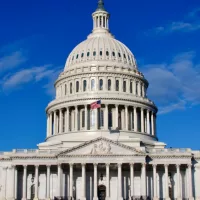 Washington DC Capitol Building facade under blue sky with clouds