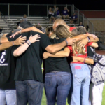 Karnes-family-huddle: The Karnes family shares a group hug.