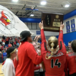 NCOE-celebration2: Senior Hollan Everett hoists the Sectional championship plaque while celebrating with the NCOE student section.