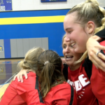 NCOE-celebration: NCOE head coach Jaclyn Melton hugs seniors Lydia Vinyard, Bree Vollman, and Hollan Everett after the Fighting Cardinals beat St. Anthony to win the Webber Sectional championship.