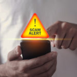 man-holding-smartphone-scam-alert