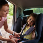 woman-puts-her-daughter-in-the-child-car-seat-and-fastens-the-child-with-a-seat-belt-safety-of-traveling-in-a-car-with-children