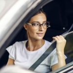 a-young-girl-is-sitting-in-her-car-and-putting-on-the-seat-belt-she-is-just-received-her-driving-license