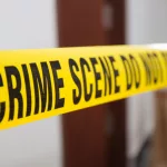 crime scene tape in front of room door with blurred background