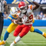 KC Chiefs running back Kareem Hunt #29 runs past LA Chargers linebacker Daiyan Henley #0 during an NFL football game at SoFi Stadium^ Aug. 17^ 2024^ in Inglewood^ Calif.