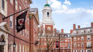 View of the architecture of the famous Harvard University in Cambridge^ Massachusetts^ USA showcasing it brick buildings with some students and locals passing by . Cambridge^ MA^ USA - March 15^ 2024