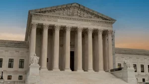 Greek classical architecture of the United States Supreme Court building with sunrise in background.