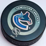 Official Vancouver Canucks game puck on the ice ^product shot