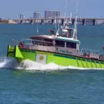 Miami-Dade fire-rescue boat patrolling on Biscayne Bay with Julia Tuttle causeway bridge in the distant background. Miami Beach^Florida^U.S.A. 13 March2021