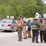Florida Everglades June 28^ 2025 Protesters line the highway in the Florida Everglades to oppose the construction of "Alligator Alcatraz"^ a new immigrant detention center.