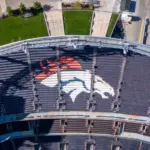 Aerial Top-Down View of Denver Broncos Logo in Empty Stadium Seats at Empower Field May 26^ 2022 Denver^ Colorado