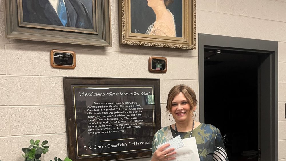 judy-martin-with-portraits-and-donation-check-and-books