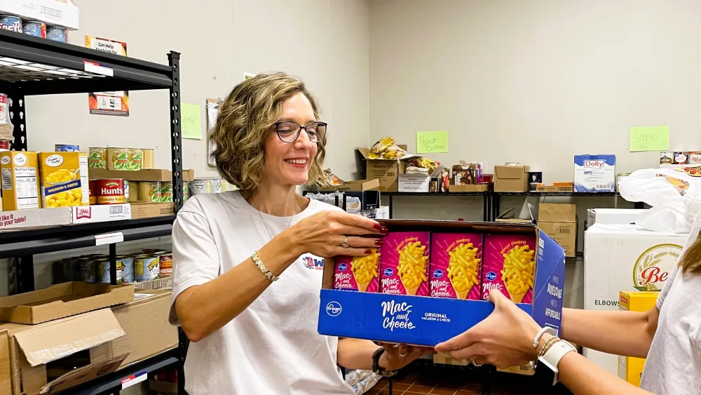 kathy-dodson-and-bethany-allen-stock-the-shelves-of-the-pantry-with-food-from-second-harvest-food-bank