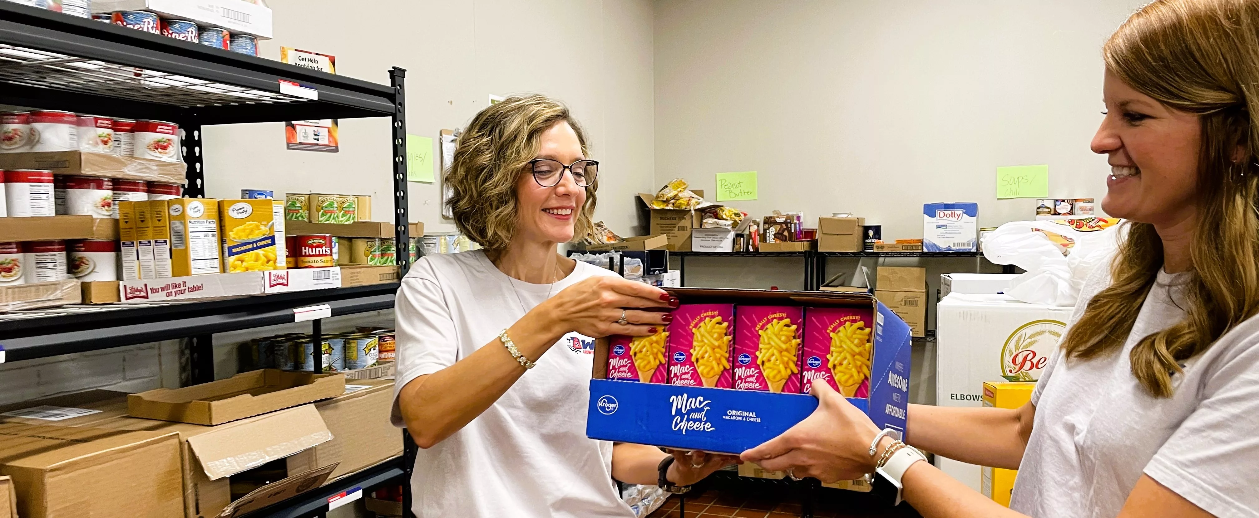 kathy-dodson-and-bethany-allen-stock-the-shelves-of-the-pantry-with-food-from-second-harvest-food-bank