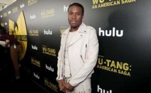Shameik Moore wearing white looking at the camera.