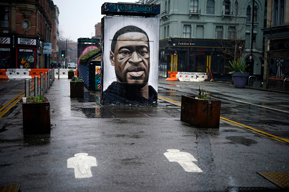 MANCHESTER, UNITED KINGDOM - JANUARY 13: Social distance markers adorn the deserted pavement in front of a mural of George Floyd in Manchester during lockdown three on January 13, 2021 in Manchester, United Kingdom. On Monday January 4th England entered its third lockdown due to the Coronavirus pandemic. Schools and colleges moved to online learning, mixing with people outside households and bubbles was curtailed and non-essential food shops closed.