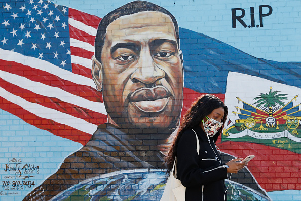 A pedestrian walks past a mural painted by artist Kenny Altidor depicting George Floyd on a sidewall of CTown Supermarket on March 9, 2021 in the Brooklyn borough New York City.