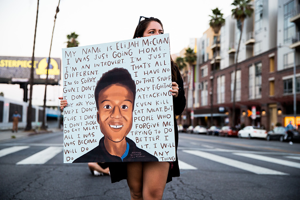 A person holds a sign at a candlelight vigil to demand justice for Elijah McClain on the one year anniversary of his death at The Laugh Factory on August 24, 2020 in West Hollywood, California.