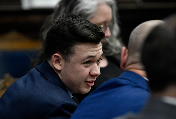 KENOSHA, WISCONSIN - NOVEMBER 18: Kyle Rittenhouse speaks with his attorneys before the jury is relieved for the evening during his trial at the Kenosha County Courthouse on November 18, 2021 in Kenosha, Wisconsin. Rittenhouse is accused of shooting three demonstrators, killing two of them, during a night of unrest that erupted in Kenosha after a police officer shot Jacob Blake seven times in the back while being arrested in August 2020. Rittenhouse, from Antioch, Illinois, was 17 at the time of the shooting and armed with an assault rifle. He faces counts of felony homicide and felony attempted homicide.
