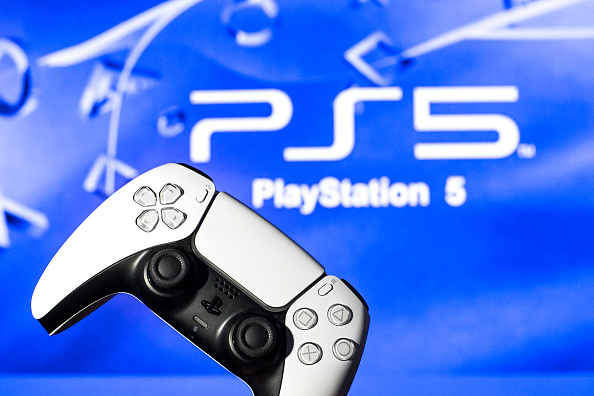 In this photo illustration, a PlayStation 5 controller seen with a PlayStation 5 logo in the background.