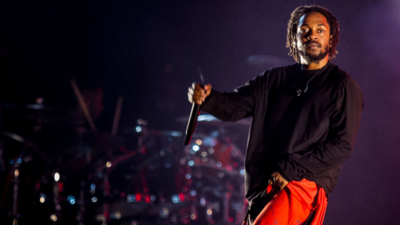 Kendrick Lamar performing in orange pants in 2019.
