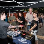 KLBJ Rocks The Nutty Brown Featuring Bob Schneider: KLBJ worker handing a listener a Koozie