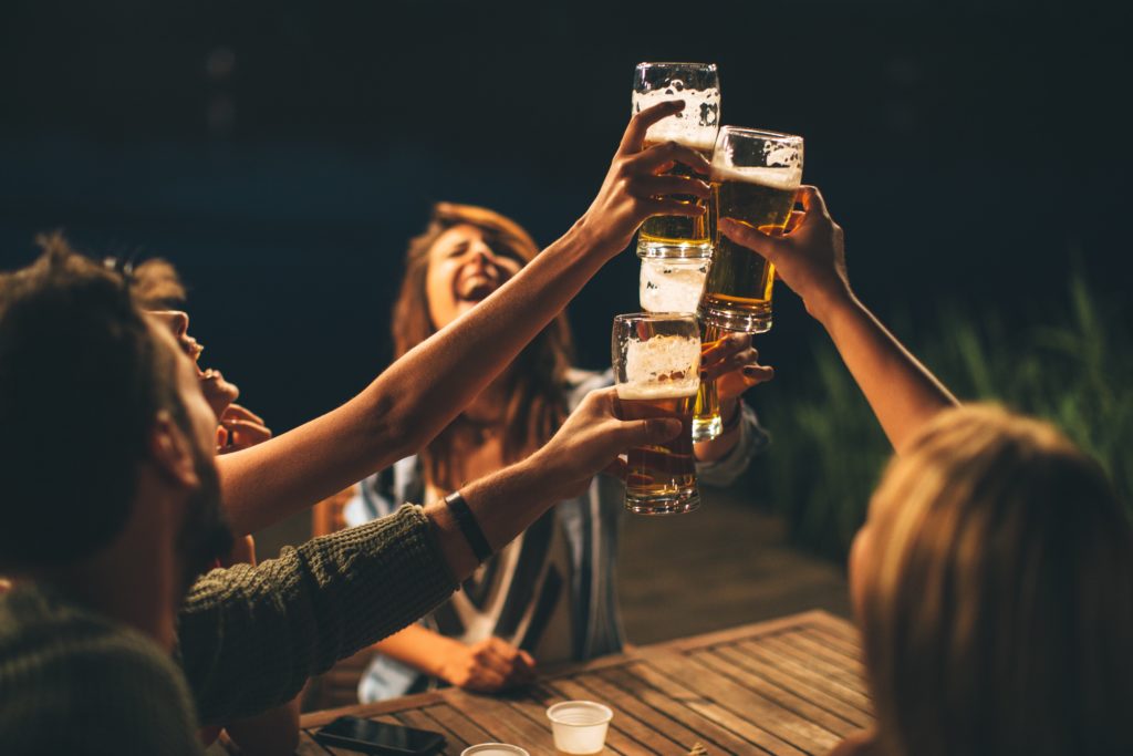 groupoffriendsdrinkbeerontheterraceandtoast