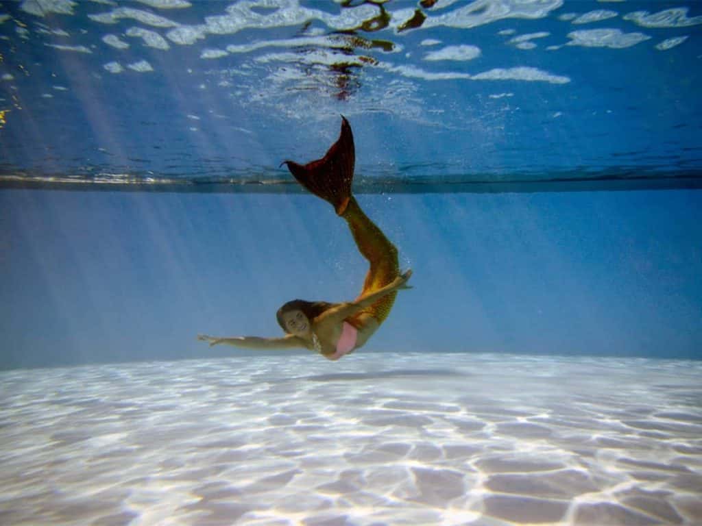 Mermaid swimming under water in a pool