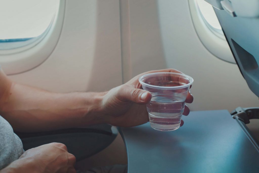 person drinking water on a plane
