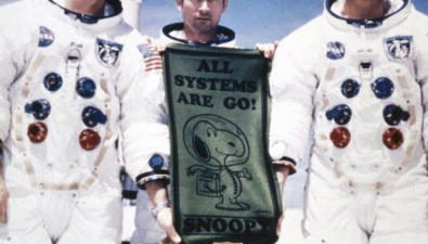 3 Astronauts from APOLLO 10 mission holding a banner with snoopy on it
