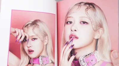 Fan hands holding BlackPink BORN PINK 2nd Album photobook with Rose on grey. Pink music CD in player. South Korean girl group BlackPink. Space for text. Gatineau^ QC Canada - November 10 2022.