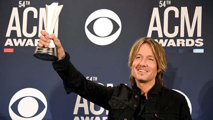 Keith Urban holding up his ACM award for Entertainer of the Year at the 54th ACM Awards
