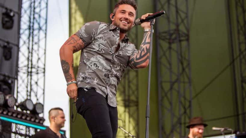 Michael ray singing on stage with camouflage shirt on