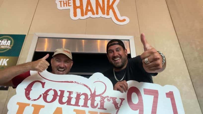 CW and Caleb holding the HANK-FM sign