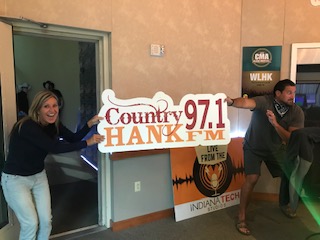 Mindy and Caleb holding HANK-FM sign