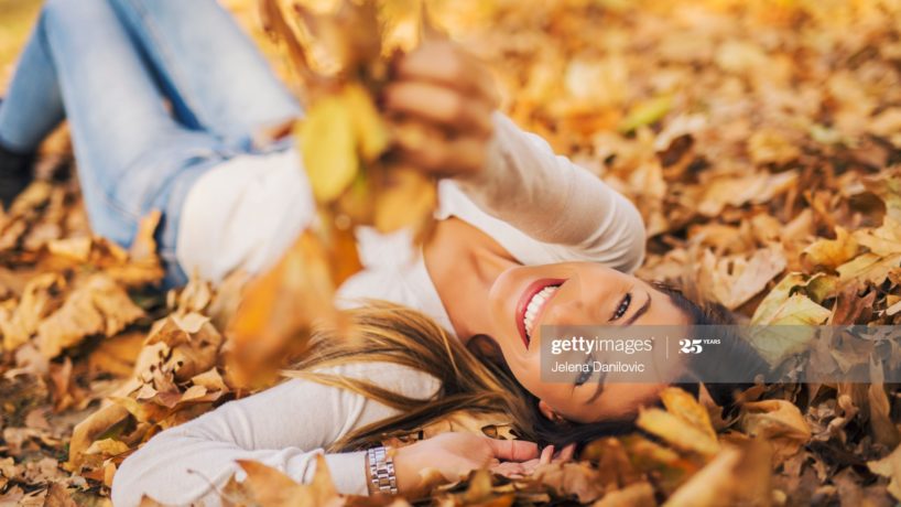 Woman lying in pile of leafs