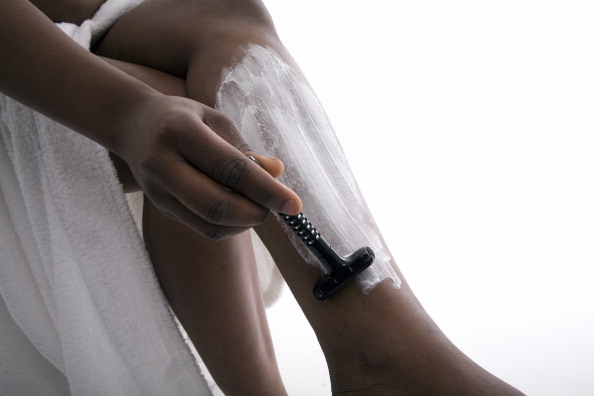 Young woman shaving her leg, close-up